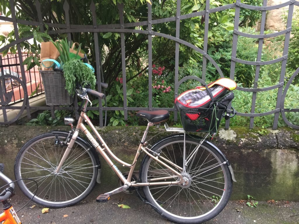 Cramming the shopping into my bike baskets, along with my son's school bag.
